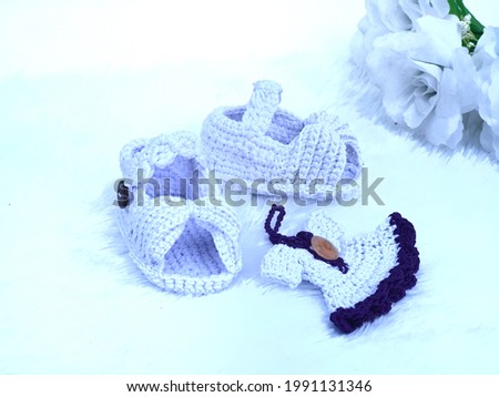White baby sandals crochet with cute baby knit souvenirs isolated on white background. For baby girls.