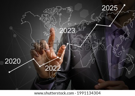 Man's hand pointing graph of success in 2023 year. Growing business concept Royalty-Free Stock Photo #1991134304