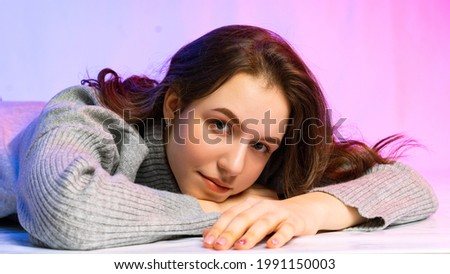 portrait of a teenage girl in a gray knitted dress. young model at the first photo session. posing