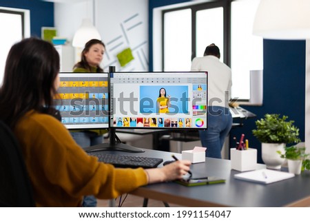 Professional photographer sitting at desk putting on headphones for listening music using PC in photo studio retouches. Content creator doing portrait retouching using post production software