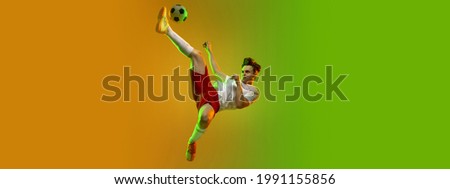 Flying and goal. Portrait of caucasian man, soccer football player in white red uniform isolated on studio background in gradient yellow green neon light. Concept of team game, energy, sport. Flyer