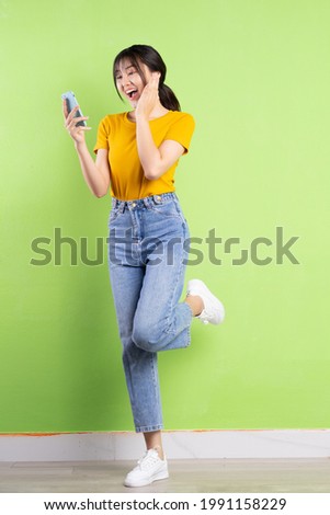 Full body portrait of young asian girl on green background
 Royalty-Free Stock Photo #1991158229