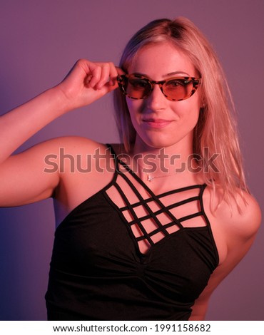 beautiful blonde girl posing in photo studio with sunglasses. High quality photo
