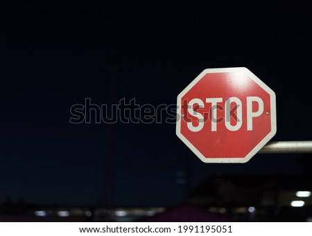 Stop sign brightly lit at night in the city