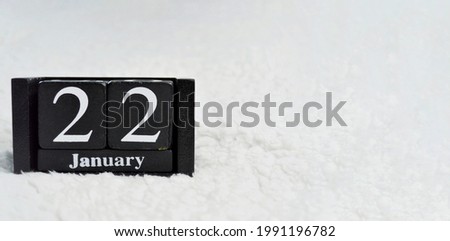Wooden calendar from blocks on a white textile background with copy space. Banner. Twenty second of January.