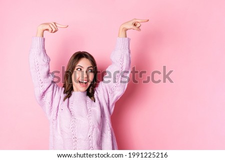 Portrait of attractive cheerful girl demonstrating copy space ad isolated over pink pastel blue color background