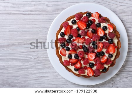 Delicious tart with fresh strawberries, raspberries and currants on the table. top view horizontal  Royalty-Free Stock Photo #199122908