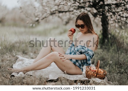 beautiful girl on a blanket near blooming trees