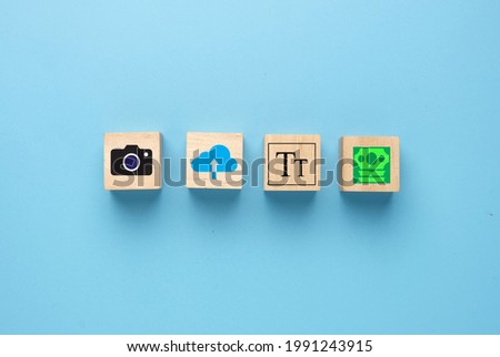 A picture of camera, upload, add title and earn money icon on wooden block. Upload your media at stock agency and earn money