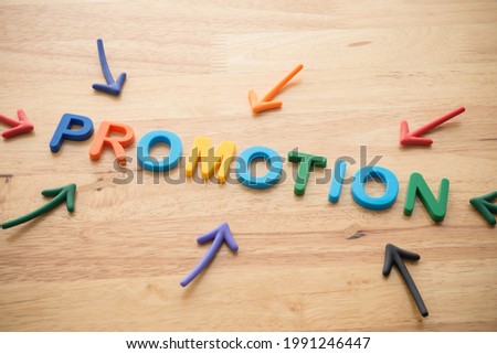 Marketing business, commerce and digital marketing strategy concept. Color highlight arrows pointing around PROMOTION letters alphabets on wooden background.