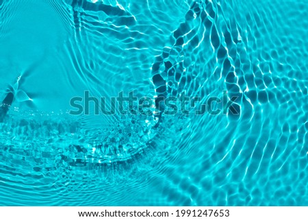 Water spills on a light blue background. Aqua waves on green background. Light and shadows.. Natural sunlight and shade. Summer mood Minimal style