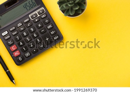 Black calculator on yellow background stock image.