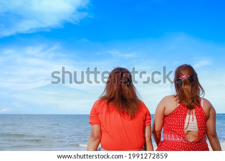 Portrait of twins asian young women at beautiful beach. Travel on vacation in summer season. Enjoy with lovely family holidays in tropical island.