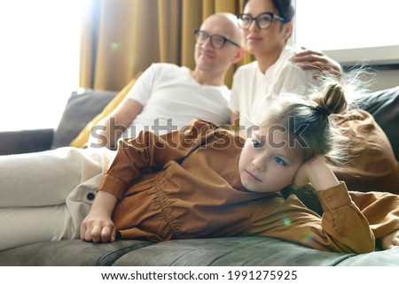 Happy family relaxing and watching TV show at home