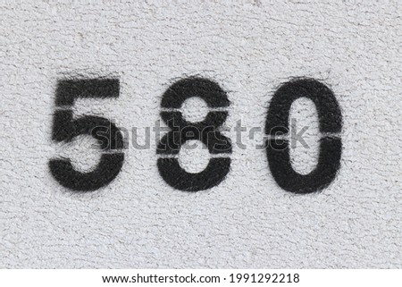 Black Number 580 on the white wall. Spray paint.