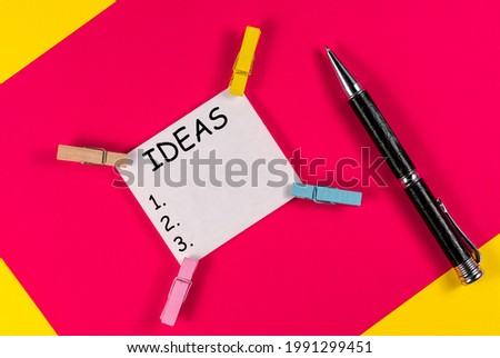 Blank colored paper sheet clips binders holders pen light background. 