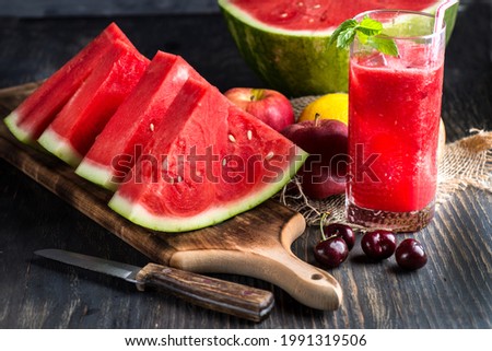 Fresh watermelon juice with ice in a glass. Slices of watermelon on the table.Fresh watermelon juice with ice in a glass. Slices of watermelon on the table. Royalty-Free Stock Photo #1991319506