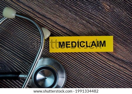 Mediclaim write on sticky notes isolated on Wooden Table.