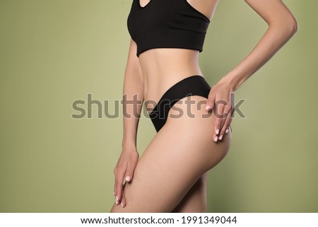 Closeup view of slim woman in underwear on light green background. Cellulite problem concept