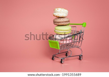 Macaroon pyramid in cart on pink background