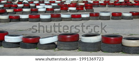 Panoramic photo of old black, red and white tires. The trajectory is set. Motion concept. Abstract set with road. 