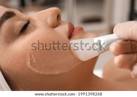 Young woman during face peeling procedure in salon, closeup Royalty-Free Stock Photo #1991398268