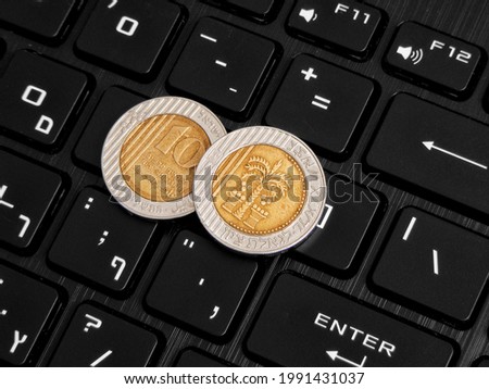 Israeli coins on the keyboard. Cryptocurrency concept.
