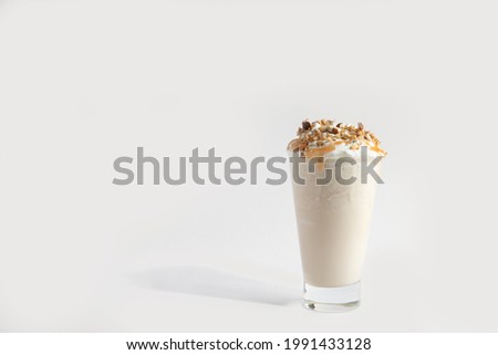 milkshakes in a glass with whipped cream and nuts. Smoothie. isolated on white background Royalty-Free Stock Photo #1991433128