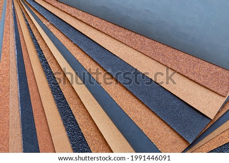 The background of the sandpaper surface, where the grains of sand on the sandpaper can be seen, and the difference in colors on the sandpaper indicate the fineness of the grains of sand. Royalty-Free Stock Photo #1991446091