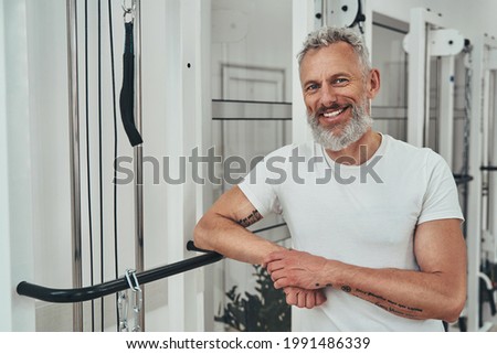 Pleased attractive athlete posing for the camera at the gym Royalty-Free Stock Photo #1991486339