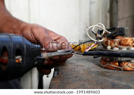 Home repair of electrical appliance, dirty hands try to repair electrical fault