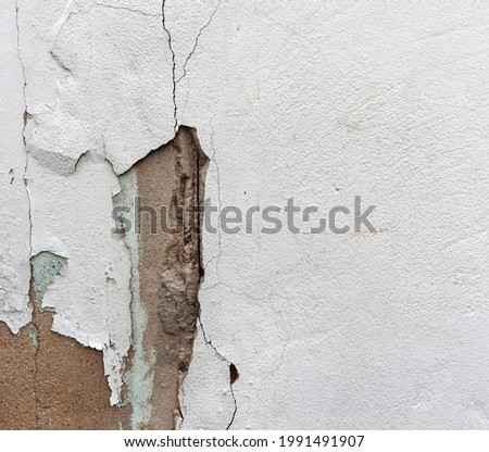 Part of wall break missing. Structure wide and deep cracks on the building. Old white wall damaged concrete moves. Empty abstract grunge texture background. copy space