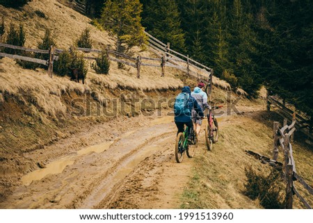 A man riding a bike down a dirt road. High quality photo