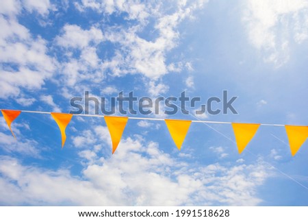 Flags in Dutch national color orange in the clear blue sky with sunlight for celebrating kings Day or EUFA Euro, World Championship support national soccer team copy space