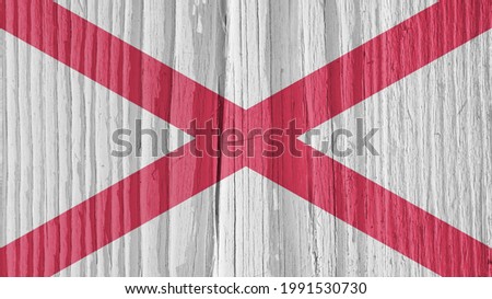 Alabama state flag on dry wooden surface. Background, wallpaper or backdrop made of old wood with the symbol of one of the US states. It seems to flutter in the wind. Hard sunlight with shadows