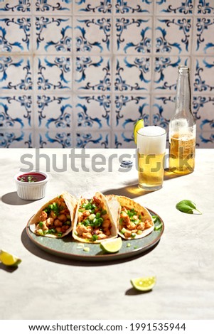Tacos with meat and herbs, sauce and lime. National Mexican street food. On a light background.