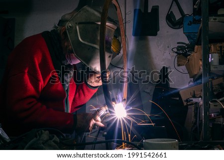 grandfather welding metal in workshop
