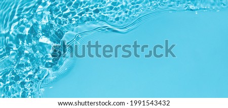 Transparent blue clear water surface texture with ripples, splashes and bubbles. Abstract summer banner background Water waves in sunlight with copy space Cosmetic moisturizer micellar toner emulsion Royalty-Free Stock Photo #1991543432