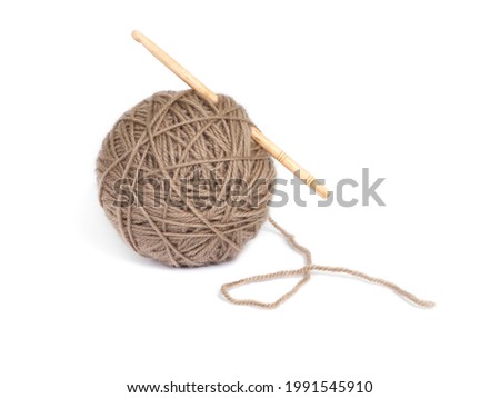 Brown yarn ball with wooden crochet on a white background. Isolated.  Royalty-Free Stock Photo #1991545910