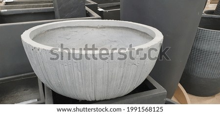 Large new pot for flowers and plants. A beautiful pot with a beautiful ornament and texture. Large pot on a shelf in a store.