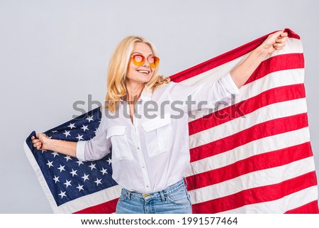 Smiling senior beautiful patriotic woman wearing united states flag isolated over white background with a surprise face.