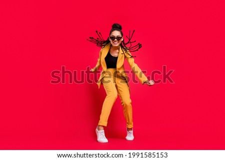 Full body photo of cool lady dance wear eyewear yellow suit isolated on vivid red color background Royalty-Free Stock Photo #1991585153