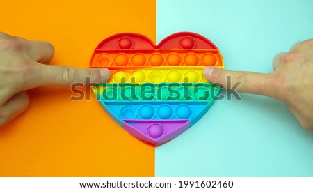 LGBT heart flag. Antistress. A popular stress reliever toy. Pressing your finger on the silicone toy Antistress. Pop it