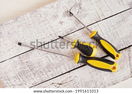 Screwdriver set on a wooden background top view copy space many screwdrivers on blue and gray old planks background Royalty-Free Stock Photo #1991611013