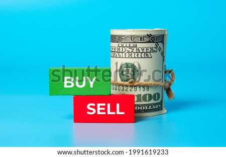 A picture fake money with Buy, Sell, green and red wooden block. Money, investment, foreign exchange and trading concept