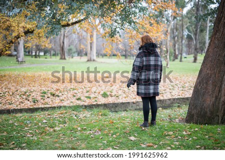 Happy woman dressed in a warm jacket in the park