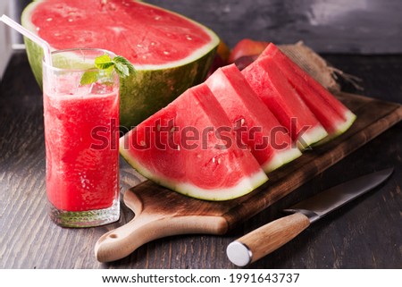 Fresh watermelon juice with ice in a glass. Slices of watermelon on the table.Fresh watermelon juice with ice in a glass. Slices of watermelon on the table. Royalty-Free Stock Photo #1991643737