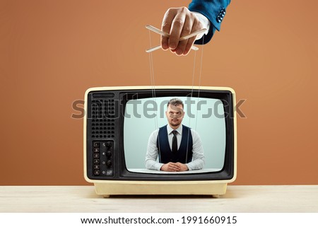 The puppeteer's male hand manipulates the news announcer, fake news, deception. The concept of shadow government, world conspiracy, manipulation, control, tabloids Royalty-Free Stock Photo #1991660915