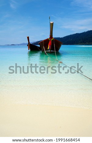 long tail boat, in white sand beach in the andaman sea