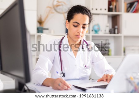 Portrait of young female doctor working on laptop at office in hospital